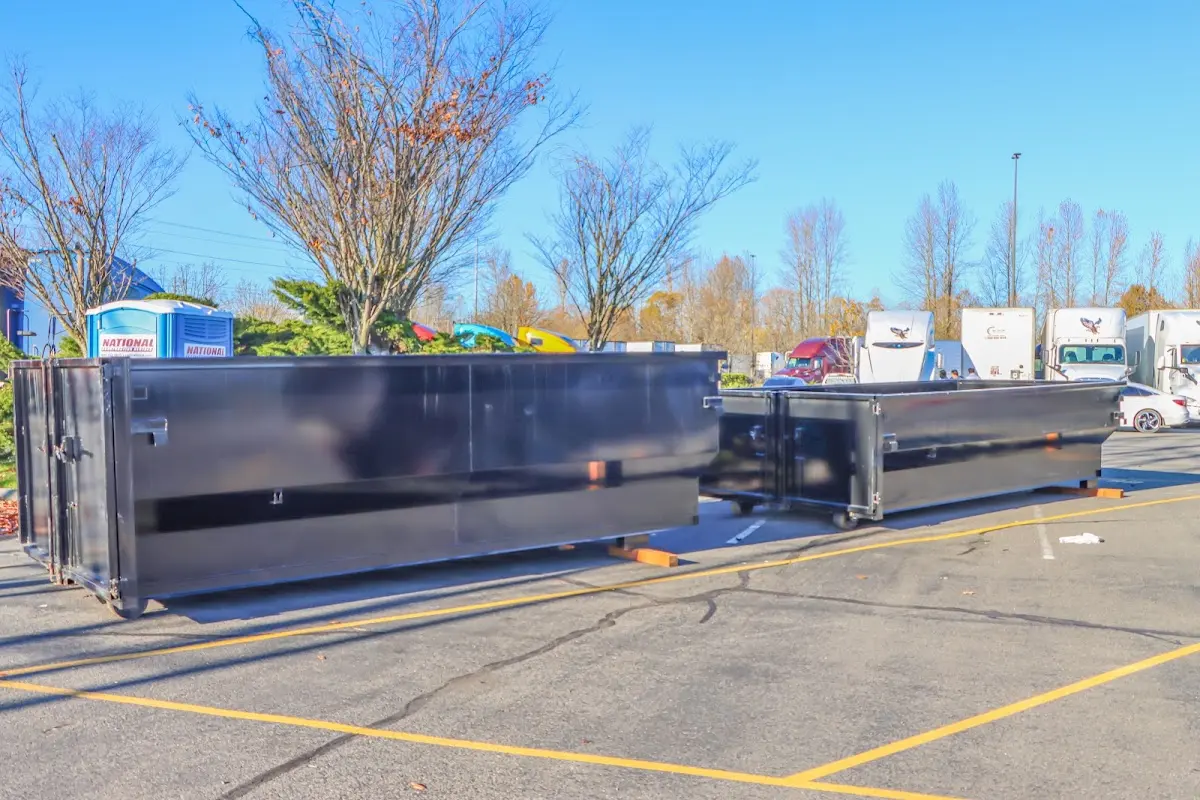 Professional dumpster rental service with roll-off container on residential driveway in Nashua